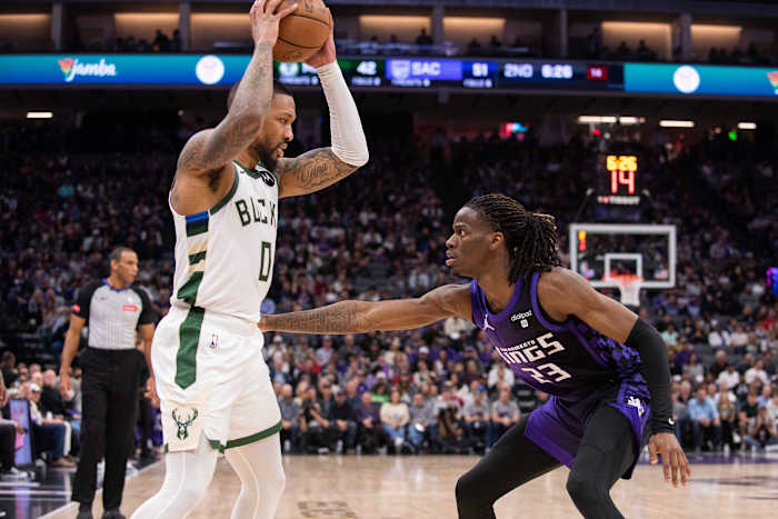 Milwaukee Bucks guard Damian Lillard (0) controls the ball against Sacramento Kings guard Keon Ellis (23)